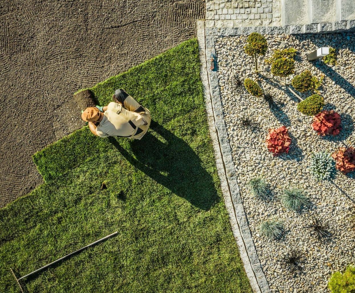 An aerial view of a landscaper mowing a freshly designed garden