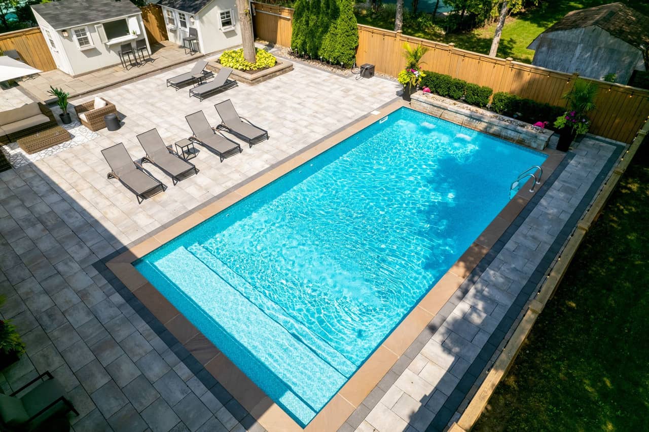 An aerial view of a large swimming pool in a backyard